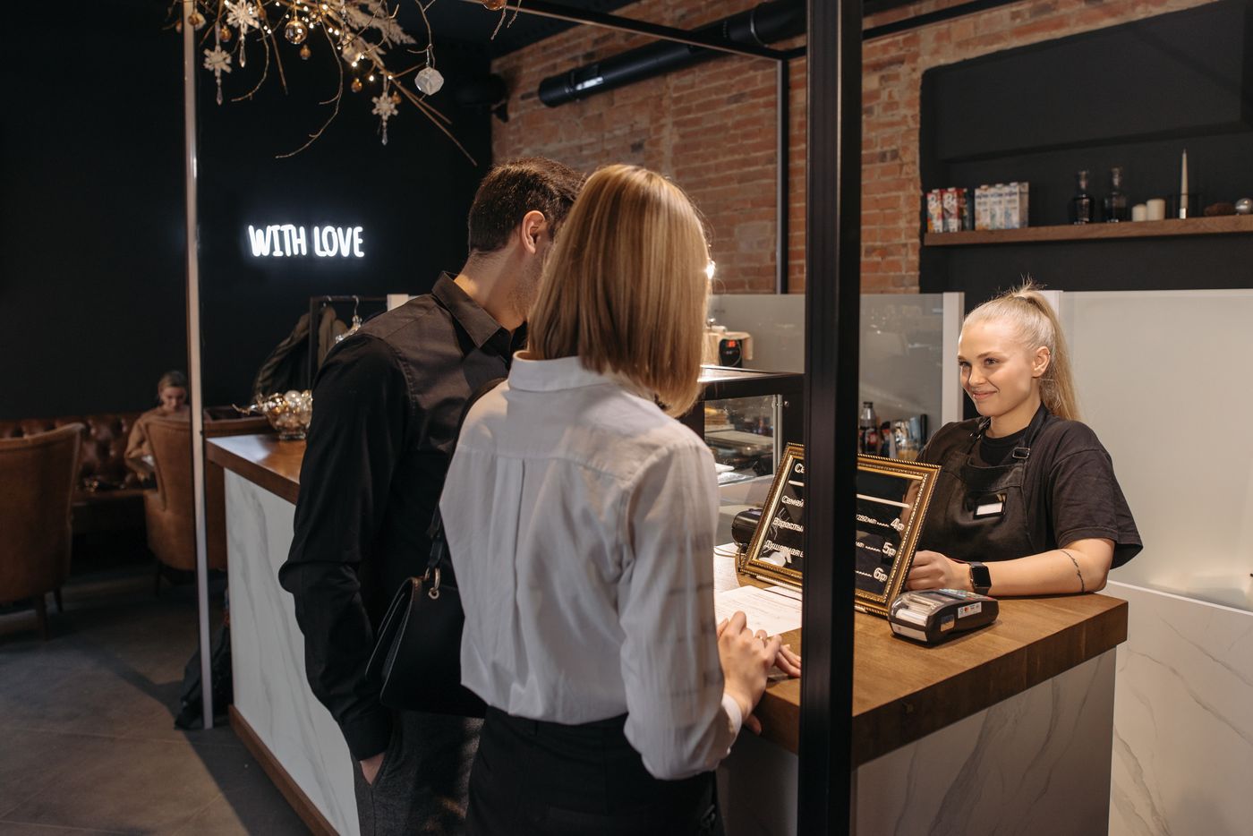 A cafe owner welcoming customers at the counter