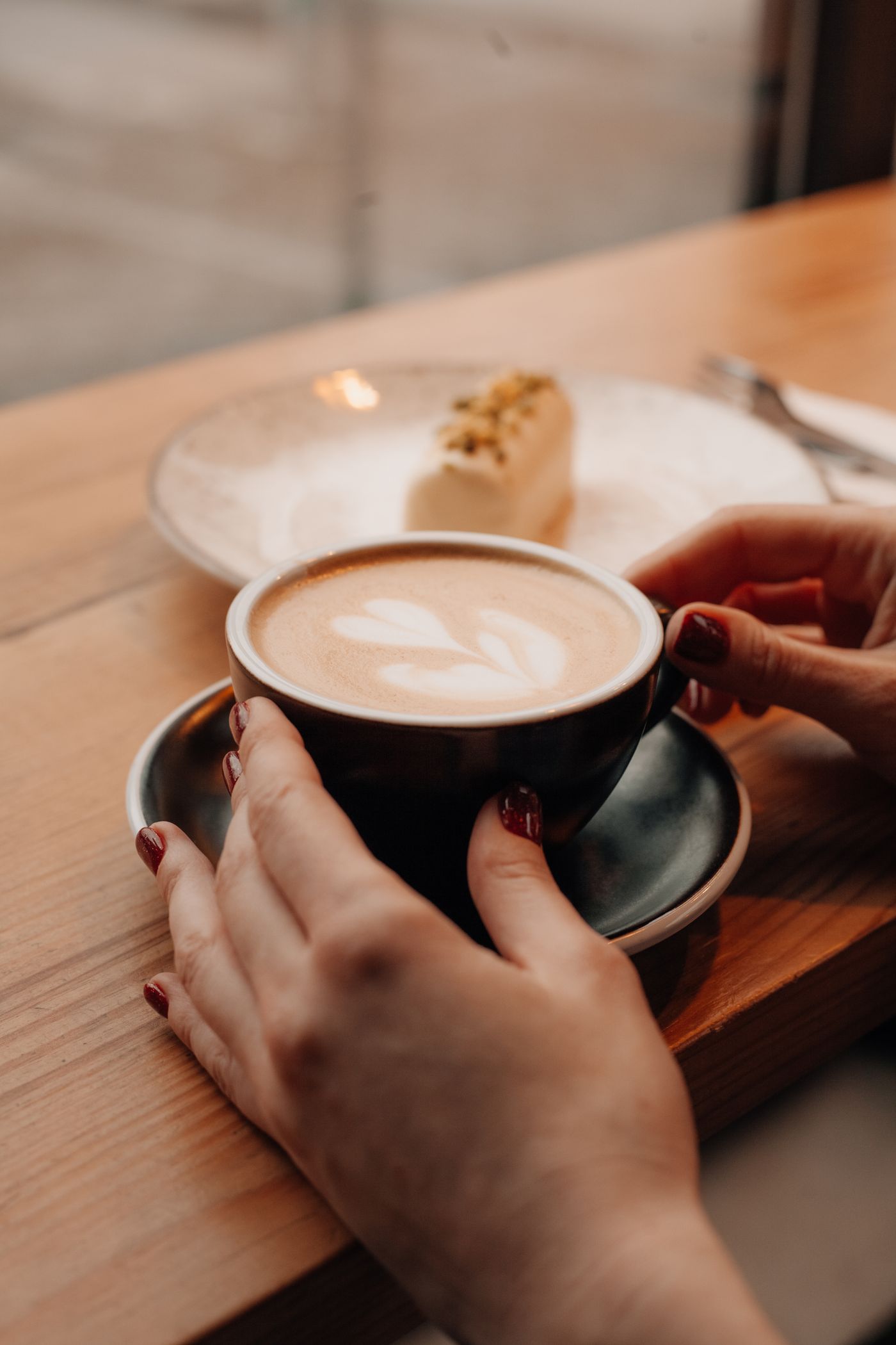 Hands wrapped around a warm coffee at a local cafe